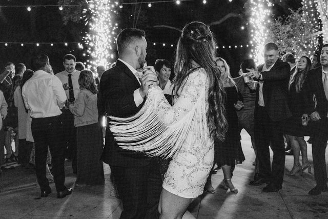 bride and groom dancing on their wedding day with sparklers in the background